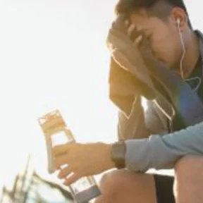 Ein erschöpter Jogger sitzt draußen