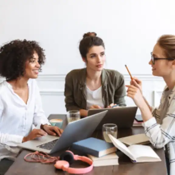 Drei Frauen mit Laptops im Gespräch